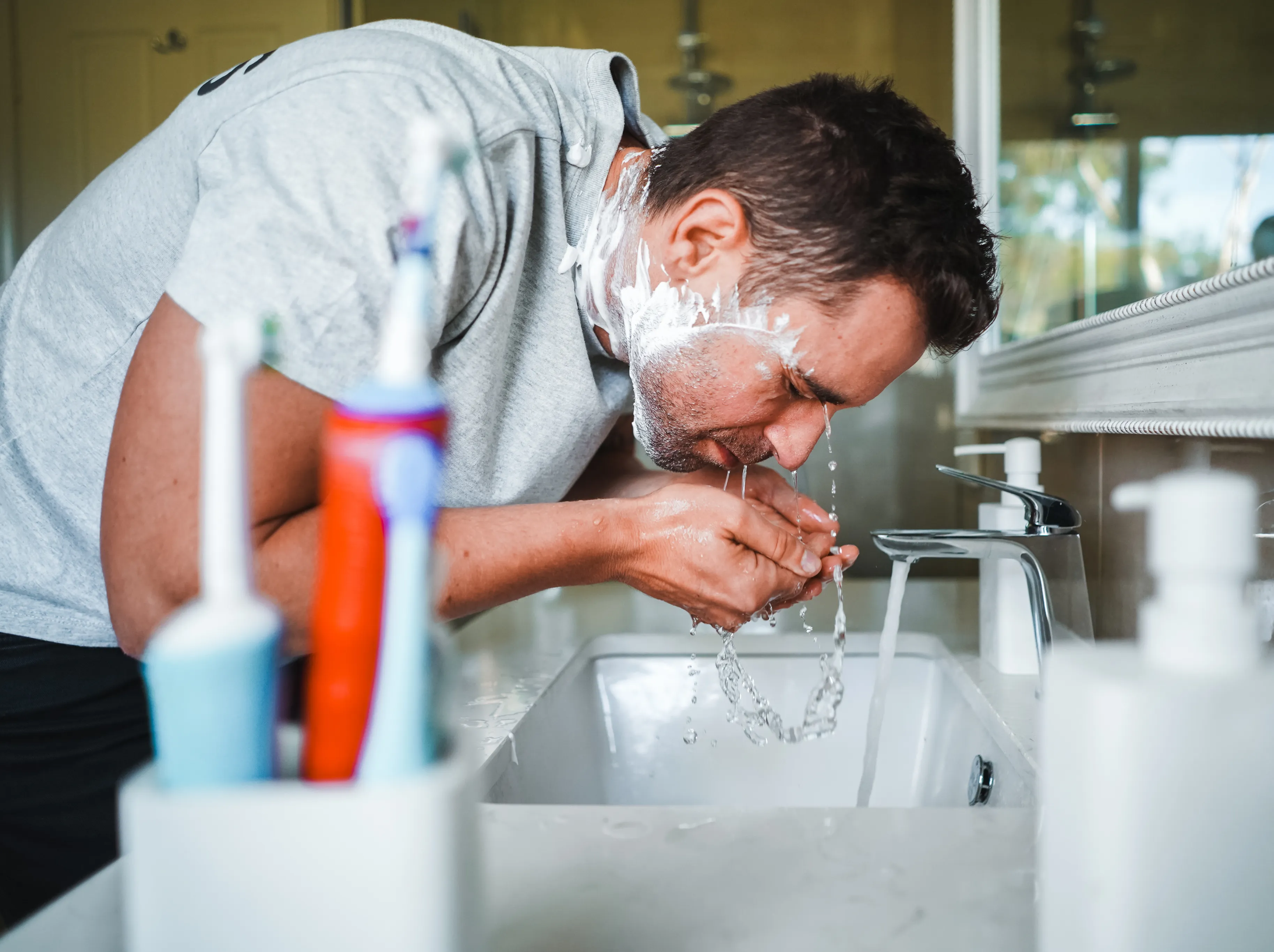 Australian family at kitchen sink enjoying purified water from OneWater system