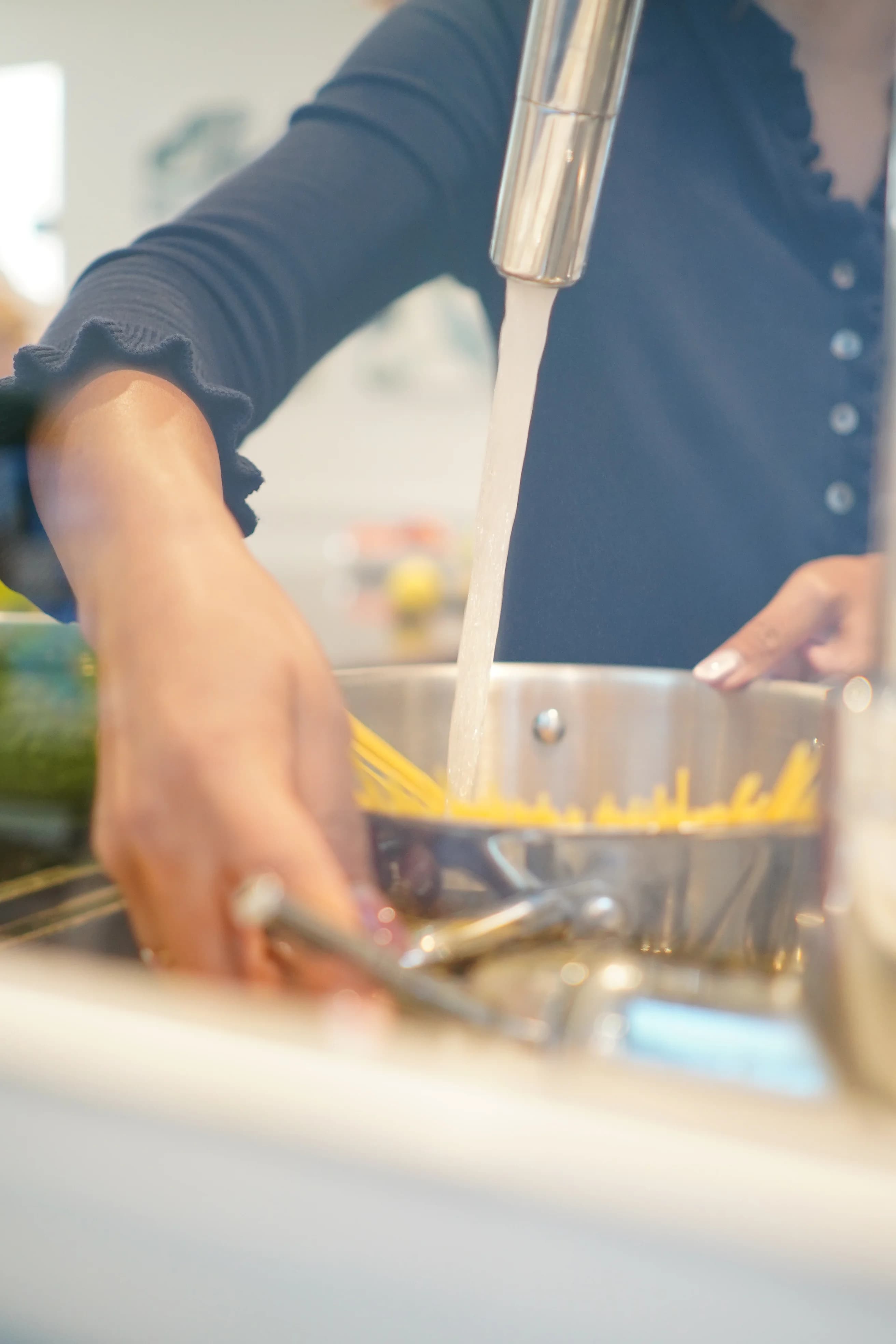Person rinsing dishes at sink